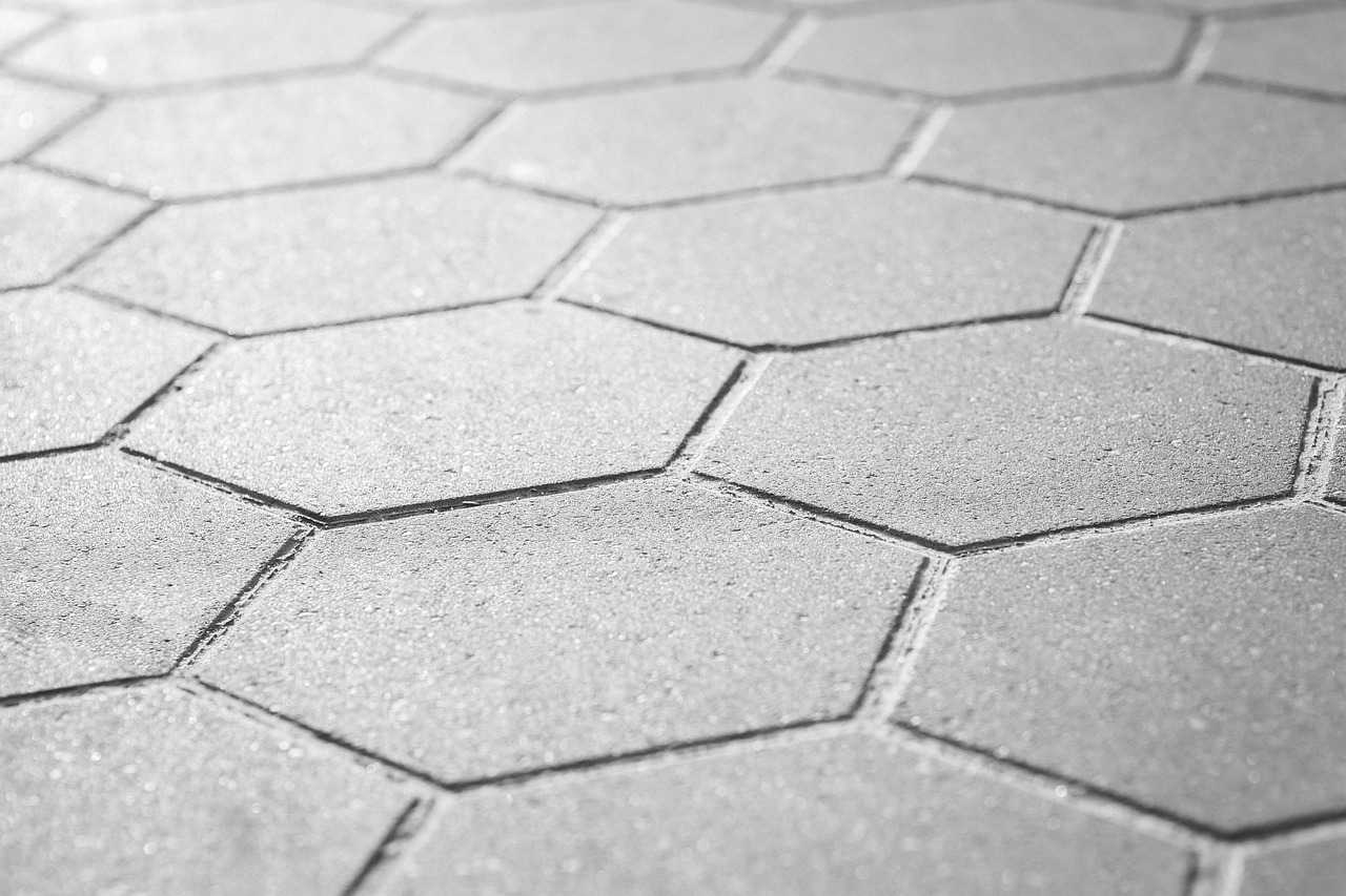 White hexagon floor tile being laid in a bathroom